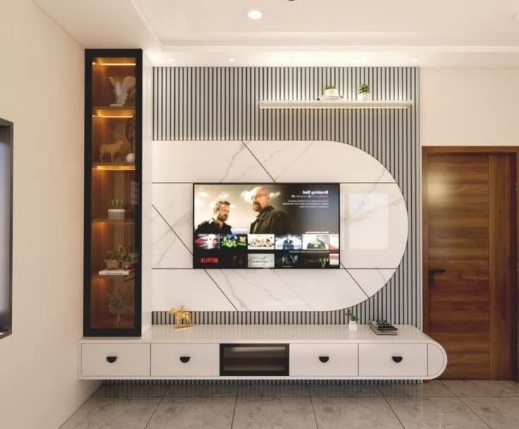 Curved marble TV unit with glass display tower by Sharma Furniture